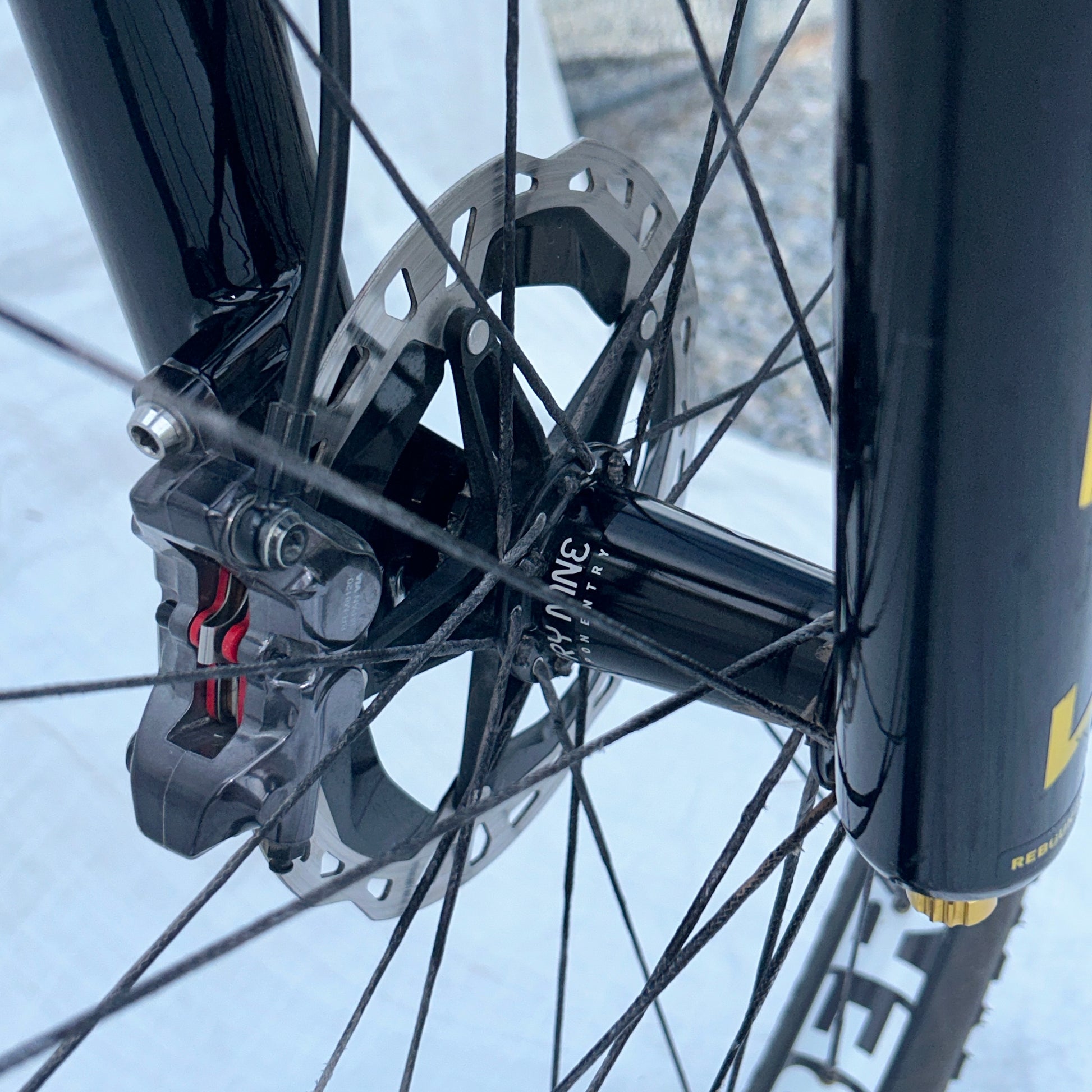 Close-up of a bicycle disc brake system with a blurred background