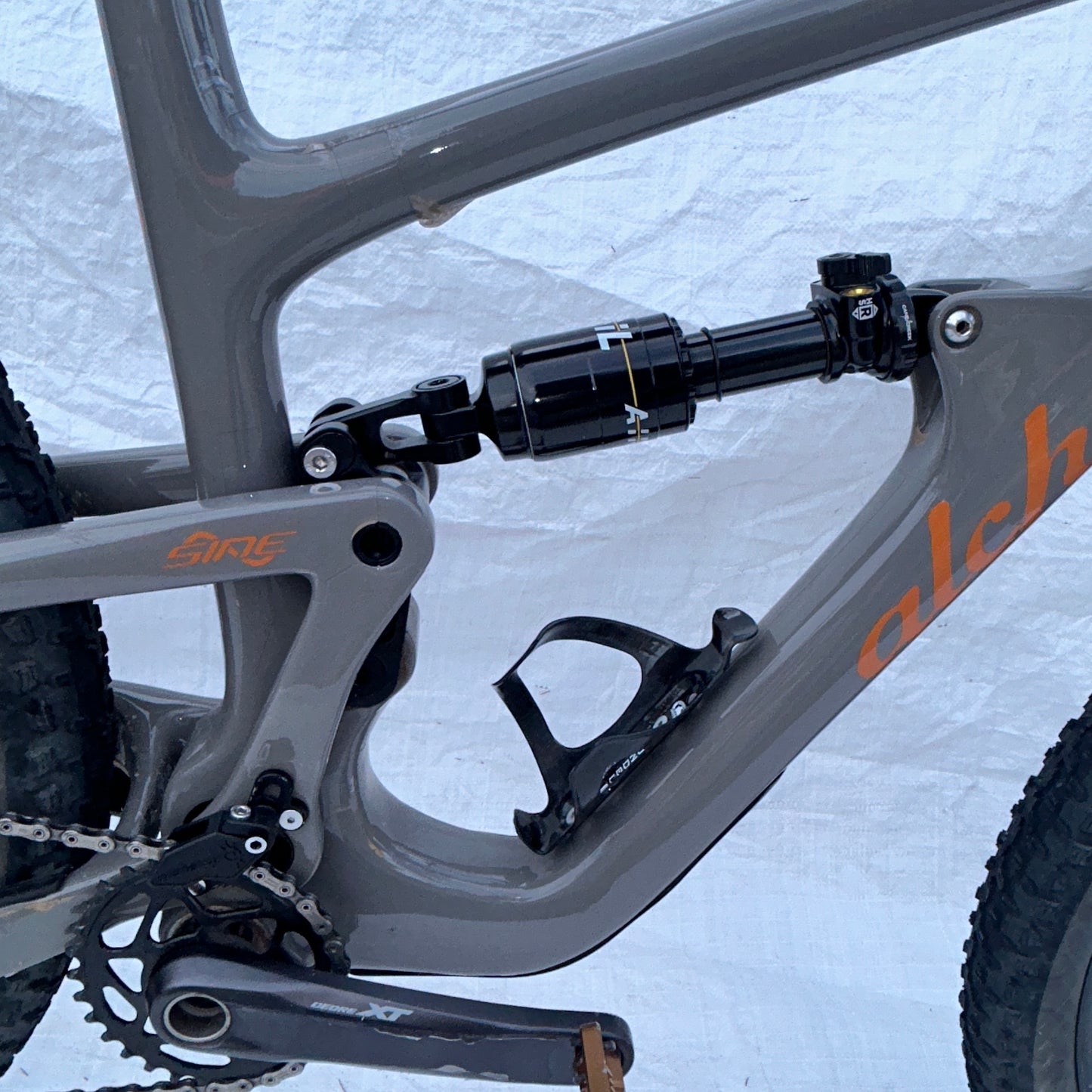 Close-up of a bicycle frame with suspension fork on a snowy background