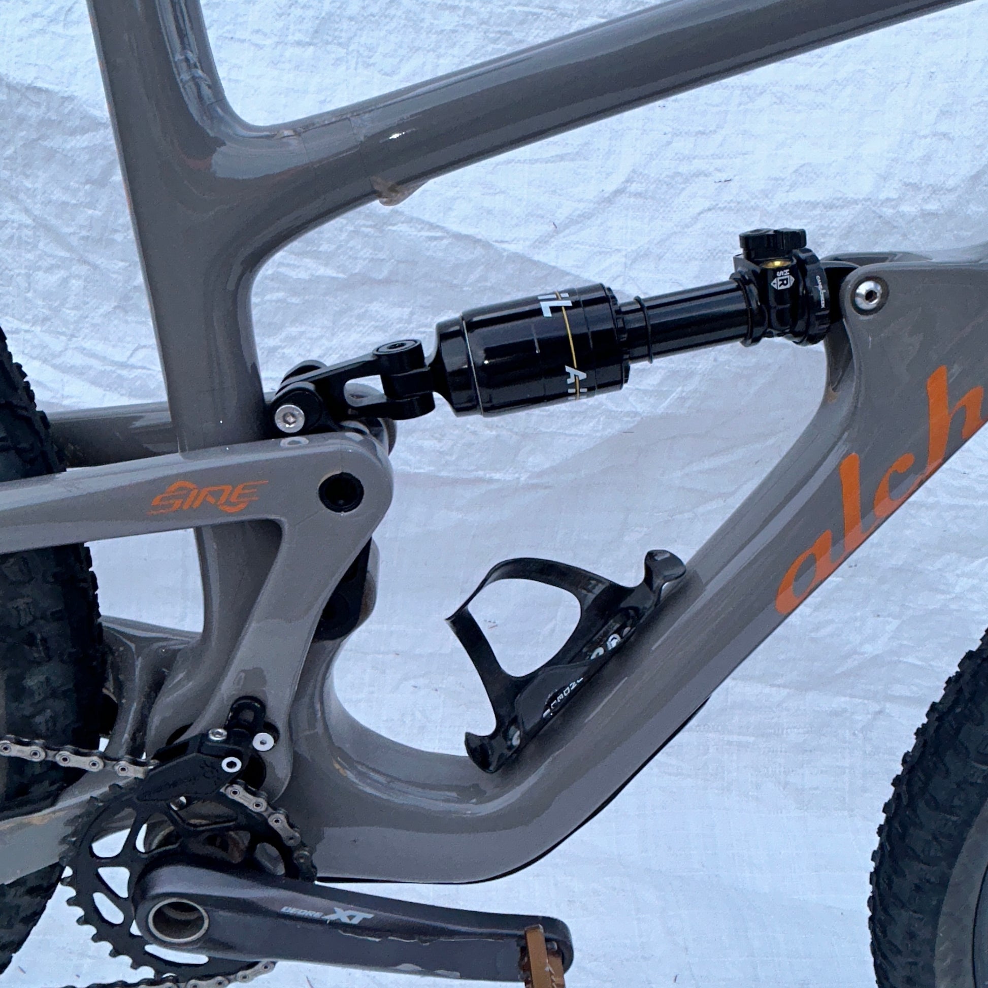 Close-up of a bicycle frame with suspension fork on a snowy background