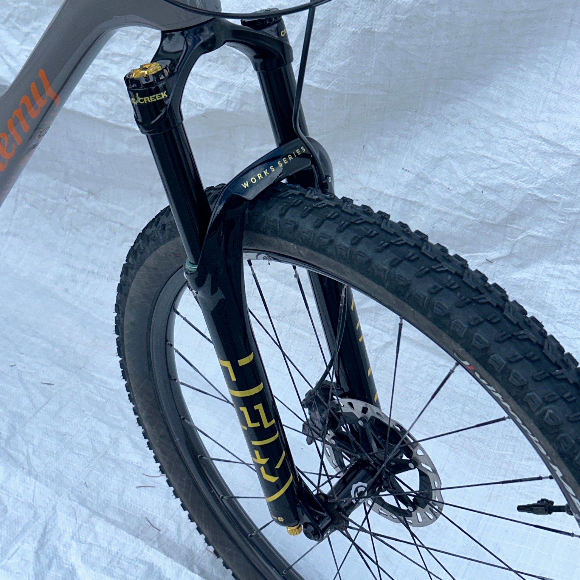 Close-up of a bicycle wheel with suspension fork on a white background