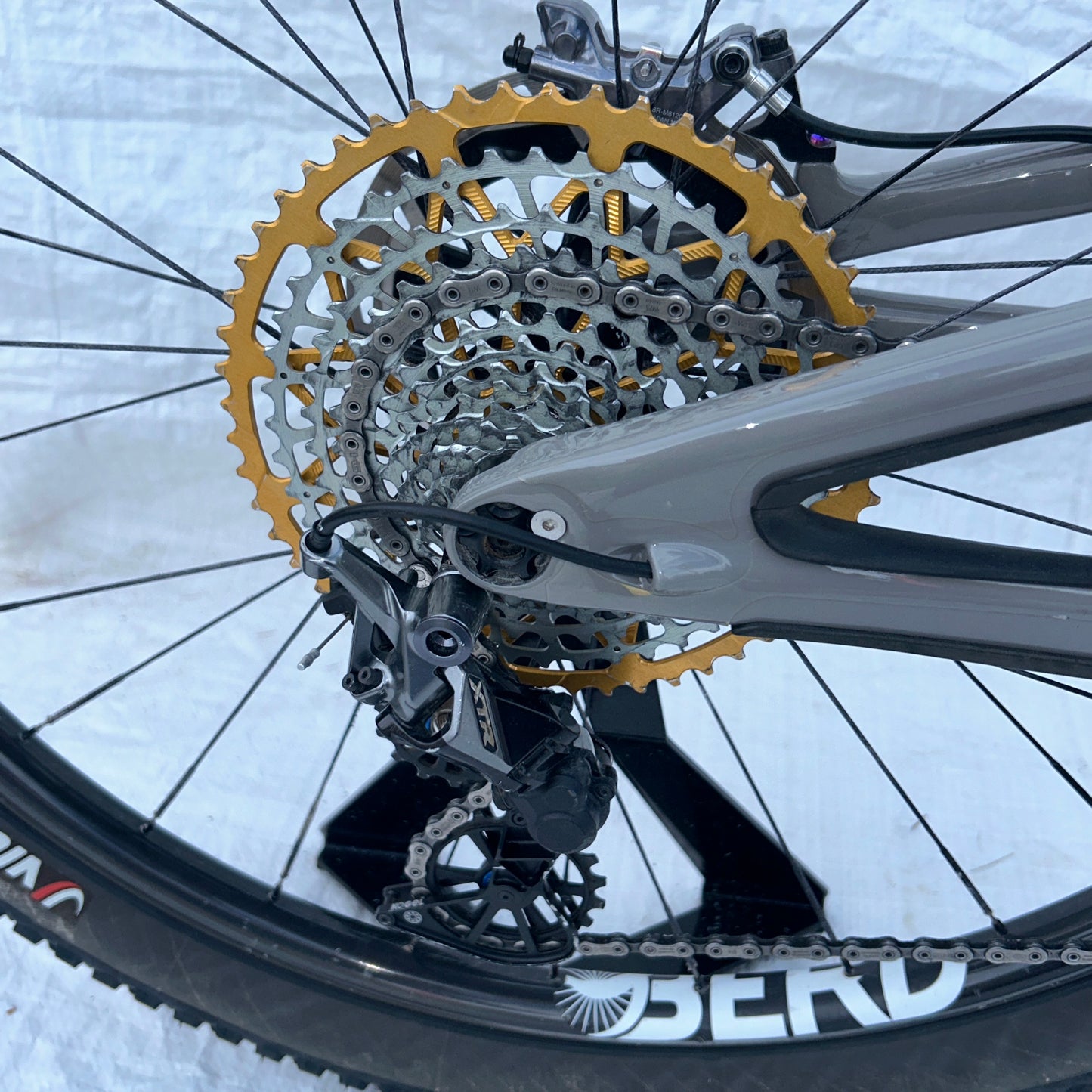 Close-up of a bicycle gear system with a snowy background