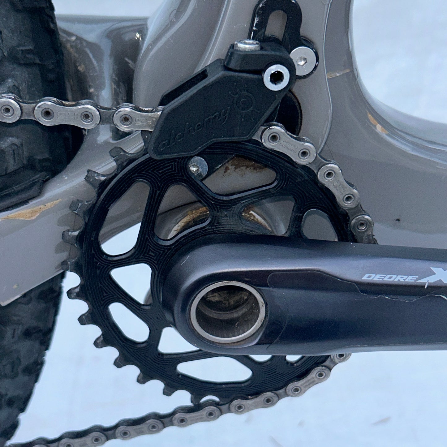 Close-up of a bicycle chain and gear system with 'Shimano' branding.