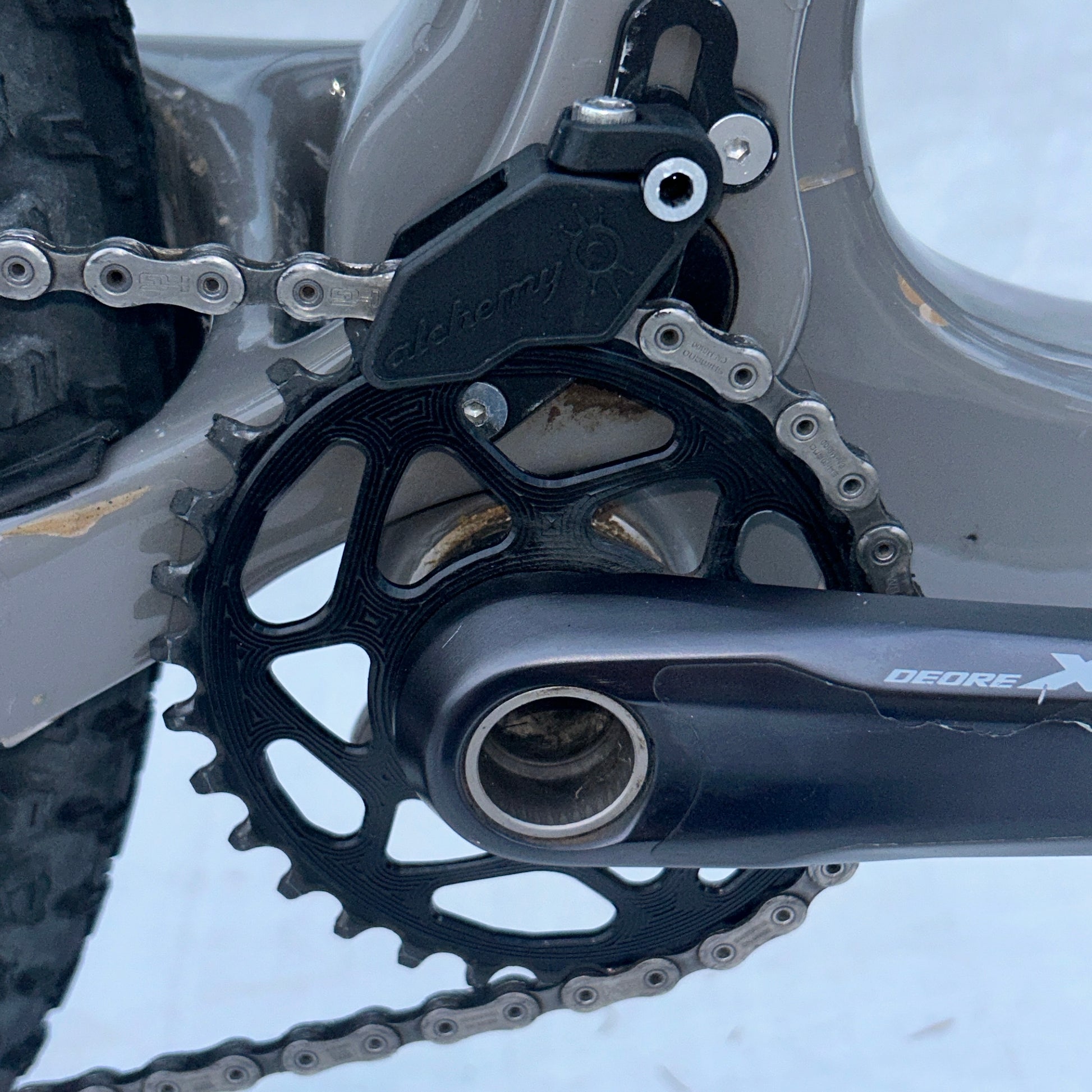 Close-up of a bicycle chain and gear system with 'Shimano' branding.